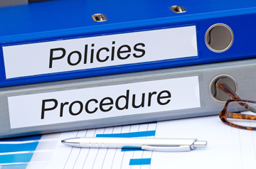 Two binders labeled Policies and Procedure respectively