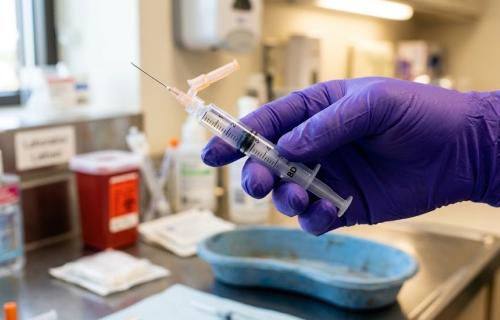 Gloved hand with needle